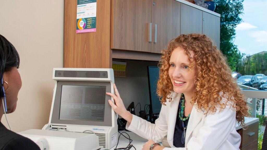 audiologist explaining hearing exam results with adult female patient