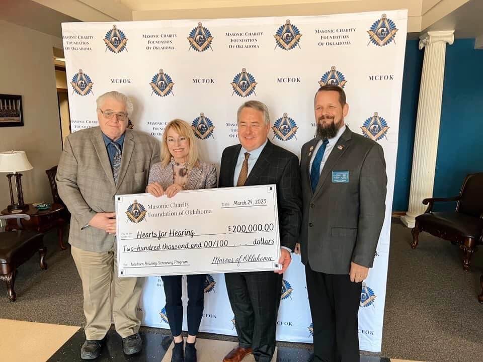 Masonic Charity Board President Neill Stiff (left) and Grand Master Glen Chaney (right) present an oversized check representing a $200,000 grant to support Hearts for Hearing’s Newborn Hearing Screen Services program and efforts to detect hearing loss as early as possible in the lives of Oklahoma babies. Accepting this generous gift on behalf of Hearts for Hearing are Chief of External Affairs, Kris Hopper, and Hardy Watkins, Chief of Strategy & Innovation.