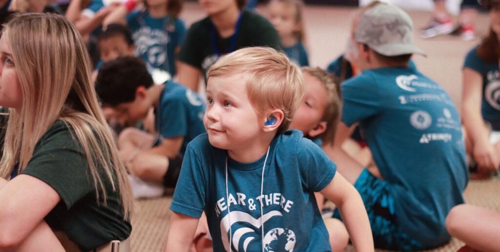 hearts for hearing summer camp students sitting together on floor