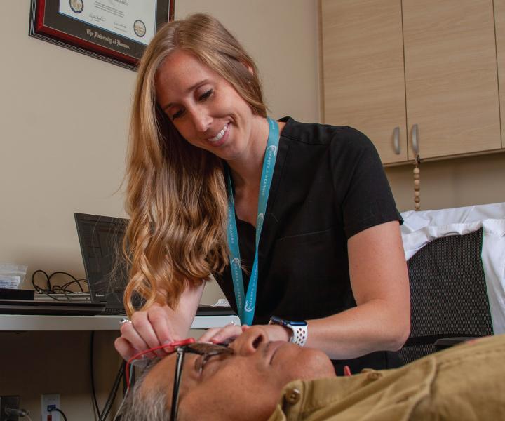 audiologist with adult patient receiving hearing examination