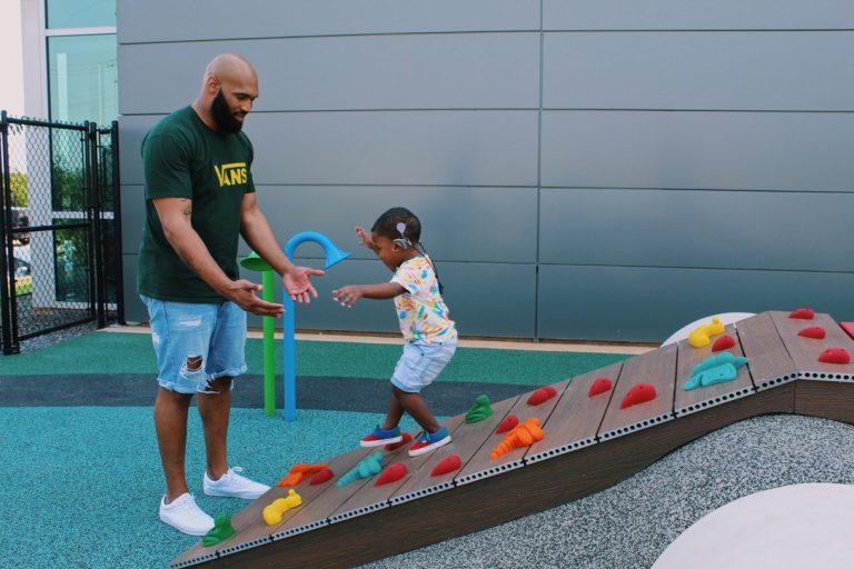 father and son playing together on playground