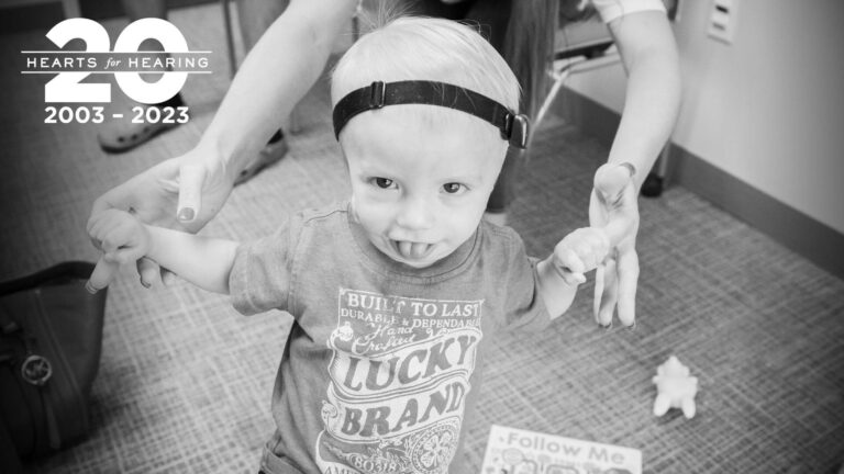 Carter walking while holding mom's hands