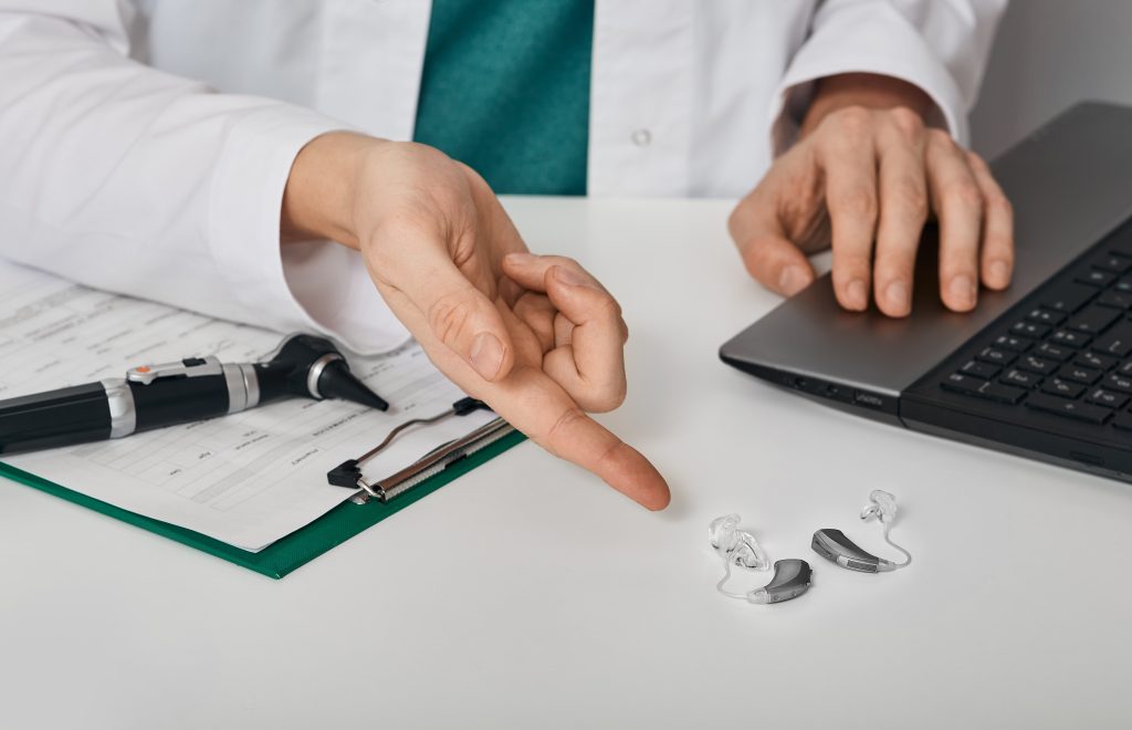 Audiologist pointing at hearing aids.