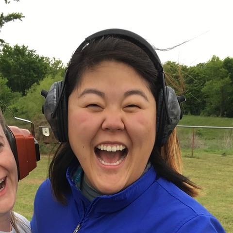 smiling adult female wearing over-the-ear hearing protection