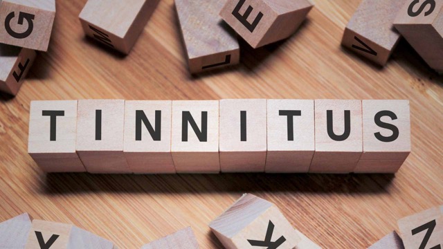the word tinnitus is spelled out with wooden blocks