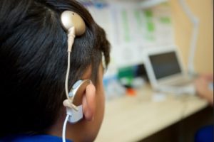 Boy with cochlear implant.