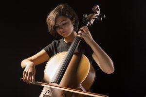 Teenager playing instrument.