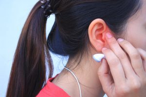 Young lady holding ear in pain.